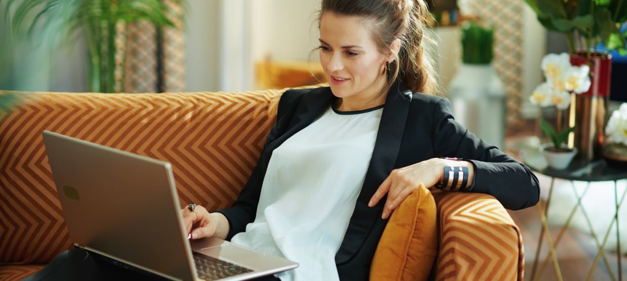 Frau auf dem Sofa mit Laptop Artikelbild zu Bildungsgutschein beantragen